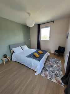 una camera da letto con un letto con due cuscini gialli di L'îlot - Cosy moderne avec parking a Bourges