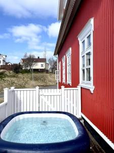a hot tub in front of a red building at The Foreman house - an authentic town center Villa in Húsavík