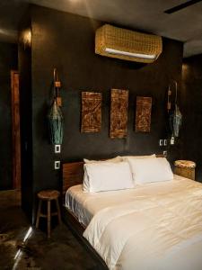 a bedroom with a white bed and a black wall at Casa Vive Bacalar in Bacalar