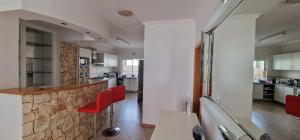 a kitchen with a counter and red chairs in it at Kaps Home - Miramar D4 in Praia