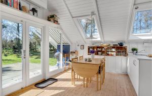 eine Küche und ein Esszimmer mit einem Tisch und Fenstern in der Unterkunft Beautiful Home In Sams With Kitchen in Nordby