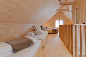 a row of beds in a room with wooden walls at PIRA HOTEL in Postojna