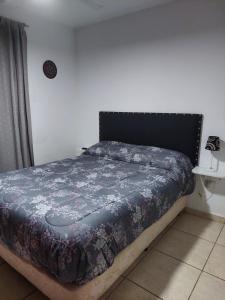 - une chambre avec un lit et une couette bleue dans l'établissement Departamento Viamonte con cochera, à Bahía Blanca