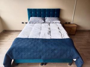 a bed with a blue headboard in a bedroom at Roma Lodges House- Campin Simón Bolivar Movistar Embajada compensar in Bogotá