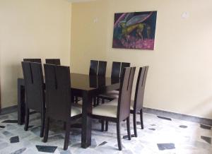 una mesa de comedor con sillas y una pintura en la pared en Roma Lodges House- Campin Simón Bolivar Movistar Embajada compensar, en Bogotá