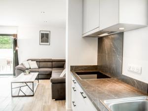 a kitchen and a living room with a couch at Lac Bleu 40 in Lacapelle-Marival