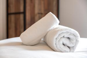 a roll of white towels sitting on top of a bed at Beryl - 2 Bedroom Flat with Parking in Southampton