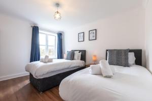 a bedroom with two beds and a window at Beryl - 2 Bedroom Flat with Parking in Southampton