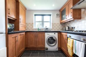 a kitchen with a washer and dryer in it at Beryl - 2 Bedroom Flat with Parking in Southampton
