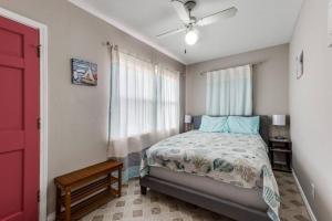 a bedroom with a bed and a ceiling fan at Cozy sea breeze bungalow - 2 mins to the beach in Galveston