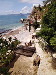 a group of benches on a beach next to the ocean at Villa Golda in Petrovac na Moru