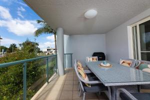 een patio met een tafel en stoelen op een balkon bij Beachside 2 in Tuncurry