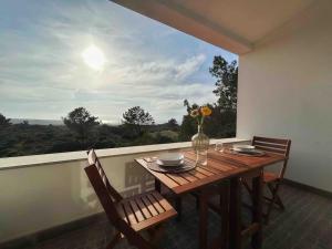 un tavolo e sedie su un balcone con vista di Olive Tree Sunset View - V3 luxo vista mar ad Aljezur