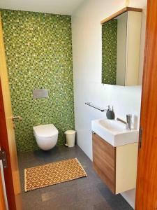 een badkamer met een toilet, een wastafel en een spiegel bij Olive Tree Sunset View - V3 luxo vista mar in Aljezur