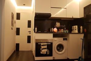 uma cozinha com uma máquina de lavar roupa em ستوديو فندقي مع مسرح منزلي روعه وواي فاي em ‘Ezbet `Abd el-Ḥamîd