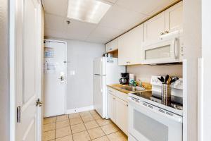 a kitchen with white cabinets and a white refrigerator at Ocean Blvd Studio, Unit 419 in Myrtle Beach