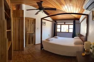 1 dormitorio con 1 cama y ventilador de techo en casa munay, en Canoa