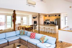 Toes in the Sand في Westhampton Beach: غرفة معيشة مع أريكة زرقاء ومطبخ