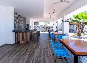 a restaurant with wooden tables and blue chairs at Departamento El Marino in Mazatlán