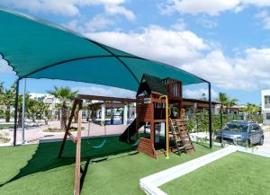 a playground with a slide and a play structure at Departamento El Marino in Mazatlán