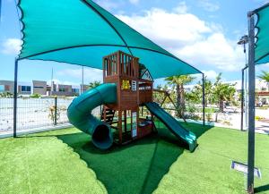 a playground with a slide and an umbrella at Departamento El Marino in Mazatlán