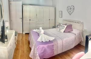 1 dormitorio con 1 cama grande con sábanas moradas y blancas en Luna Centro 5 habitaciones en Granada