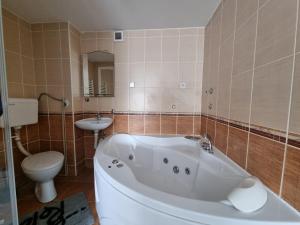 y baño con bañera, aseo y lavamanos. en Hostel S en Novi Sad