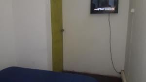 Cette chambre comprend un lit et une télévision murale. dans l'établissement Hostería Residencial Santa Rosa, à Los Andes