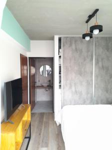a room with a bed and a tv and a mirror at Apartamento Nuevo a Estrenar in Buenos Aires