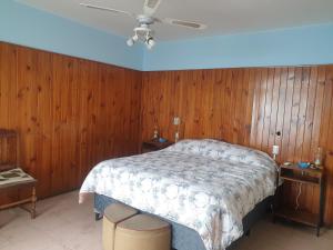 een slaapkamer met een bed met houten wanden en een plafond bij FourDoor in Guaymallen