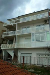 un edificio de apartamentos blanco con balcones y una valla en Apartments by the sea Dugi Rat, Omis - 21074, en Dugi Rat