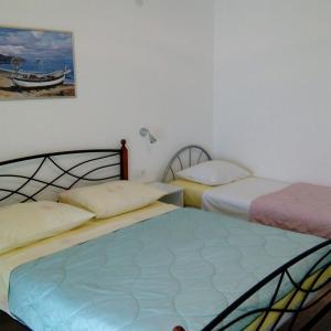 a bedroom with two beds and a painting on the wall at Apartments by the sea Dugi Rat, Omis - 21074 in Dugi Rat