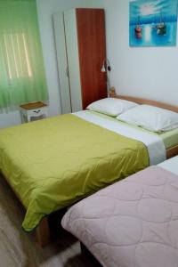 two beds sitting next to each other in a bedroom at Apartments by the sea Dugi Rat, Omis - 21074 in Dugi Rat