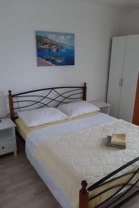 1 dormitorio con 1 cama y una pintura en la pared en Apartments by the sea Dugi Rat, Omis - 21074, en Dugi Rat