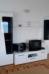 a living room with a tv and a counter with a tvictericter at Apartments by the sea Dugi Rat, Omis - 21074 in Dugi Rat
