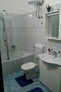 y baño con aseo, lavabo y ducha. en Apartments by the sea Dugi Rat, Omis - 21074, en Dugi Rat