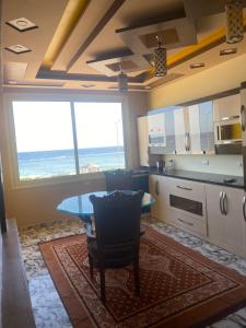 a kitchen with a table and a view of the ocean at Typique appartement avec vue sur la Mer Rouge in Quseir