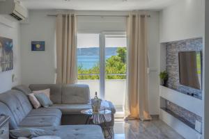ein Wohnzimmer mit einem Sofa und einem großen Fenster in der Unterkunft Apartments by the sea Kastel Stafilic, Kastela - 21087 in Kaštela