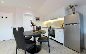 cocina con mesa, sillas y nevera en Apartments with a parking space Seliste Dreznicko, Plitvice - 21127, en Rakovica
