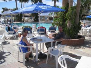 a man and woman sitting at a table with an umbrella at Beach themed La Ventana Del Mar Home with in-house WiFi in San Felipe
