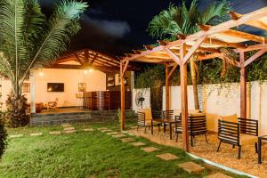 eine Terrasse mit einem Tisch und Stühlen unter einer Pergola in der Unterkunft Ahomé Guest house & Lounge in Lomé