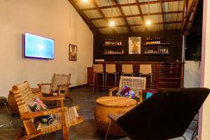 um quarto com um bar com cadeiras de vime e uma televisão em Ahomé Guest house & Lounge em Lomé