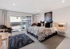 a bedroom with a bed and a large window at Dunrovin Motel in Taupo