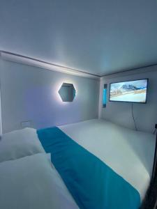 Hotel Hostal Caps El Poblado في ميديلين: غرفة صغيرة بها سرير وتلفزيون