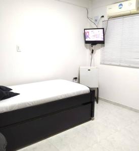 a bedroom with a bed and a tv in a room at HABITACIÓN INDEPENDIENTE CERCA AL CENTRO in Santa Marta