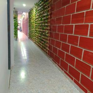 a red brick wall with ivy growing on it at HABITACIÓN INDEPENDIENTE CERCA AL CENTRO in Santa Marta