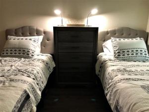 two beds sitting next to a dresser in a bedroom at Granite Apartment - Prescott Cabin Rentals in Prescott