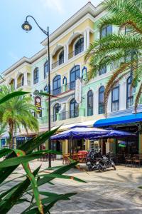 a large building with palm trees in front of it at PENGUIN HOMESTAY in Phu Quoc