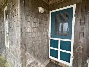 a front door of a house with a blue door at SW 1 STARFISH condo in Hatteras