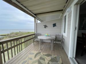 porche con mesa y vistas al océano en SW 1 STARFISH condo, en Hatteras